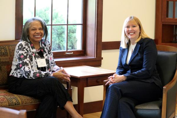Valerie and Meghan sitting in chairs near a window smiling